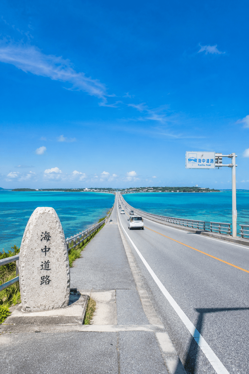 沖縄・うるま市の海中道路。青い海に伸びる橋と「海中道路」の石碑